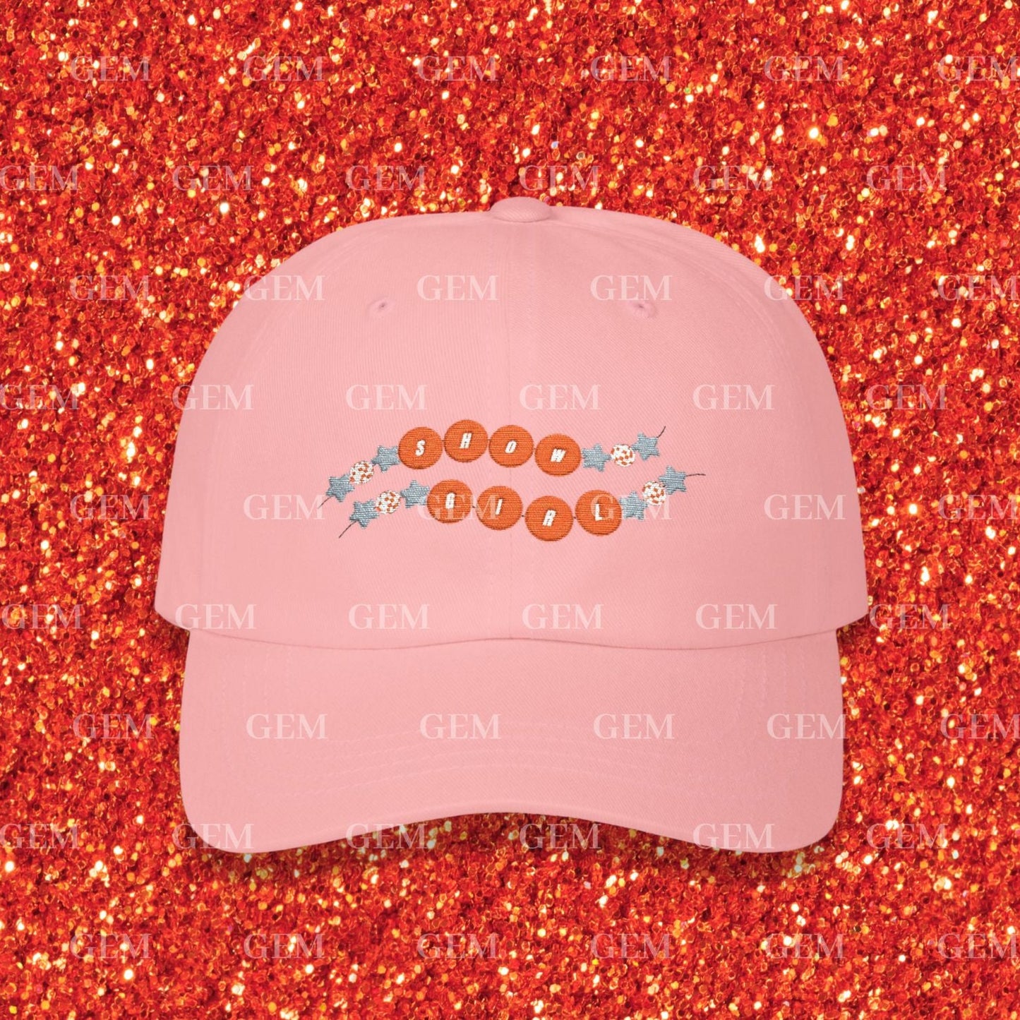 Pink cap with text and designs on a red glittery background