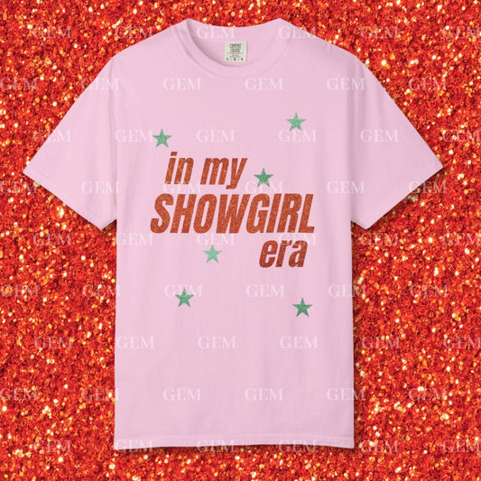 Pink t-shirt with 'in my SHOWGIRL era' text on a glittery red background